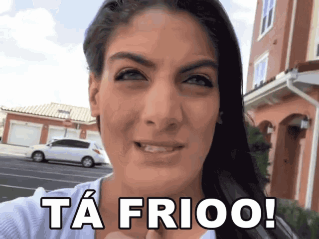 a woman says ta frioo while standing in front of a building