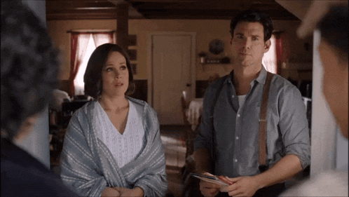 a man and a woman are standing in a living room