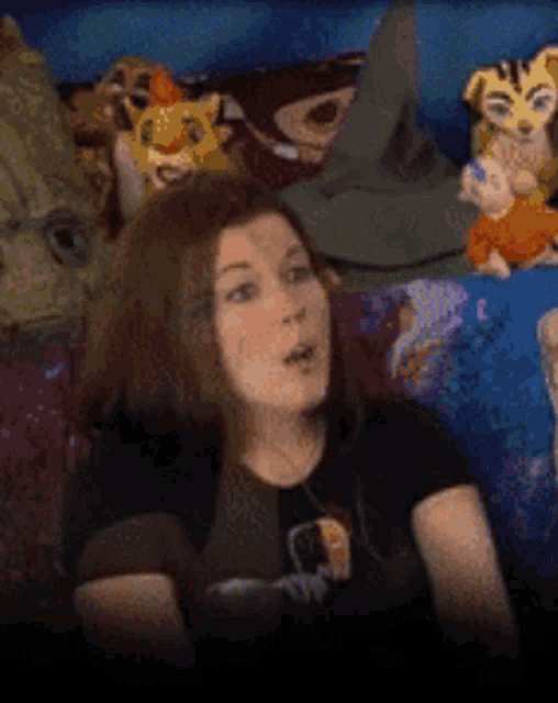 a woman is sitting on a couch with stuffed animals