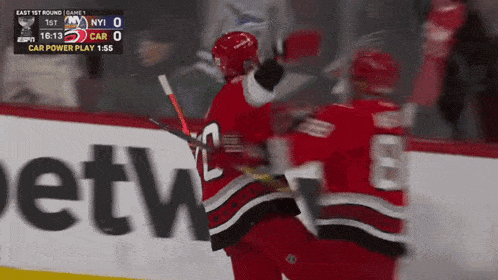a hockey game is being played in front of a netw advertisement