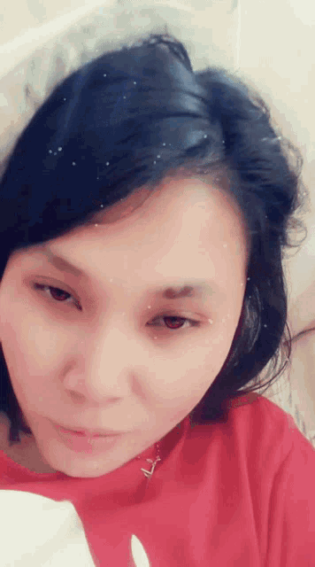 a close up of a woman 's face with a red shirt that has the letter a on it