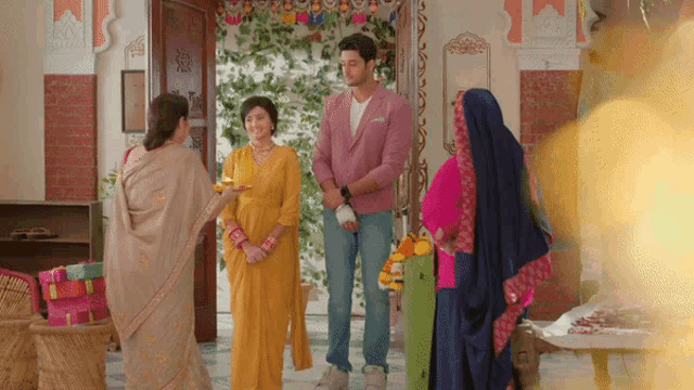 a man in a pink jacket is standing in front of a group of people