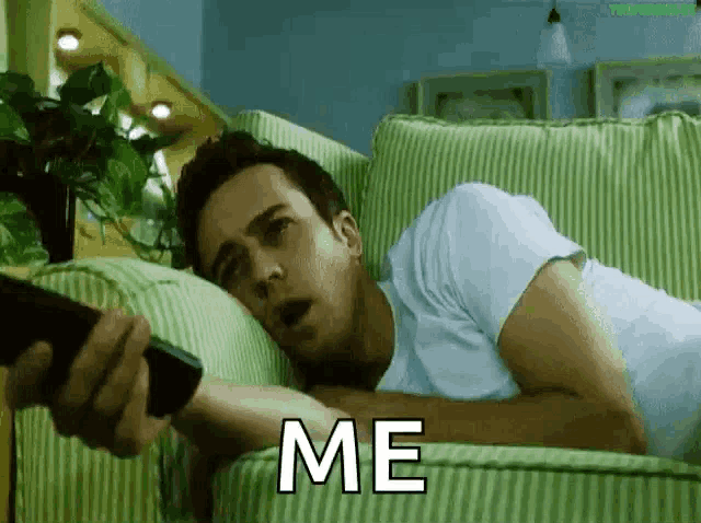 a man is laying on a couch holding a remote control and the word me is above him