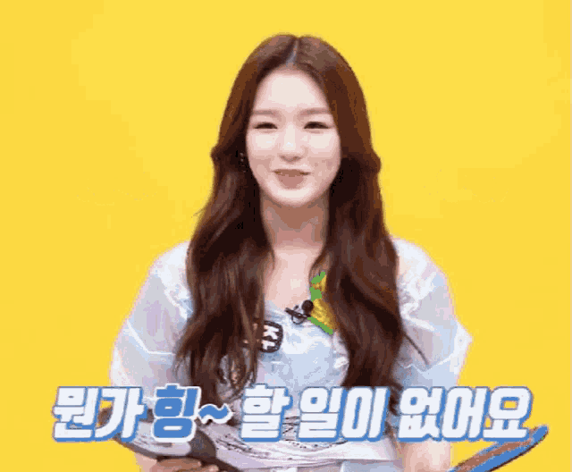 a girl with long hair is smiling and holding a book in front of a yellow background with chinese writing on it