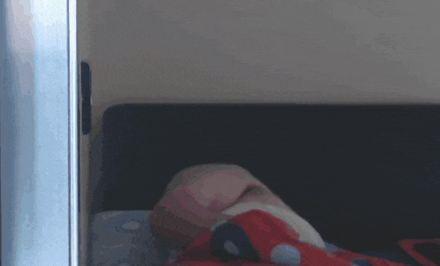 a blurred image of a person laying on a bed with a polka dot blanket