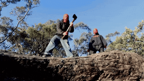 a man with a red face is holding an axe and another man with a black jacket is standing behind him
