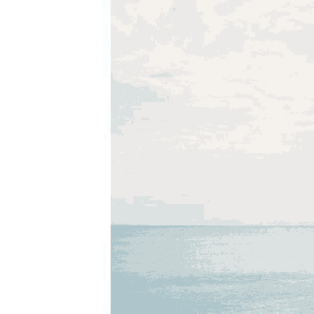 a picture of a large body of water with a cloudy sky in the background