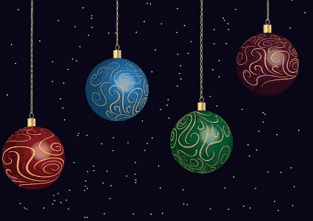 four different colored christmas ornaments hanging from chains on a dark background
