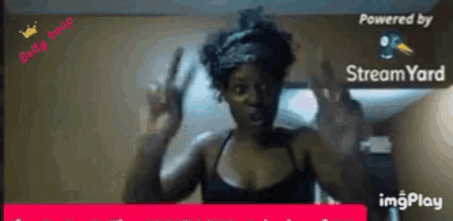 a woman is giving a peace sign while being powered by stream yard