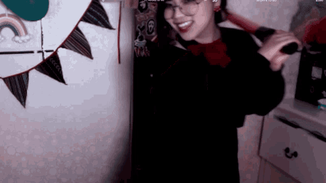 a woman with glasses is holding a bat in her hand