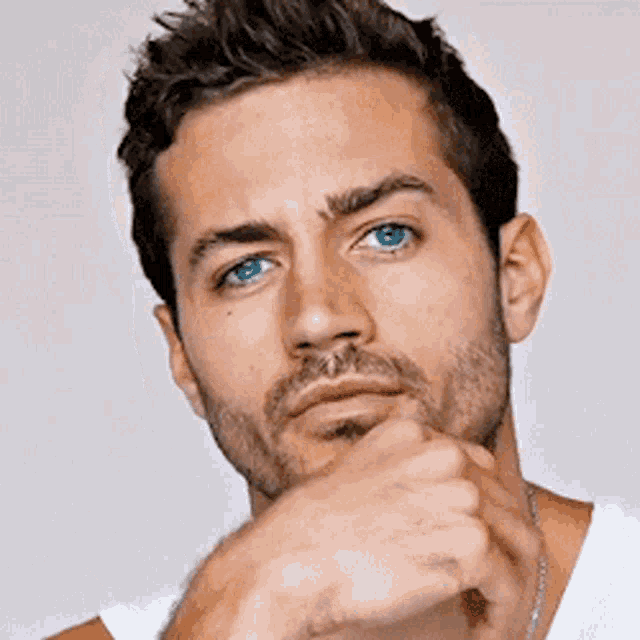 a close up of a man 's face with blue eyes and a beard
