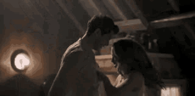 a man and a woman are standing next to each other in a room .