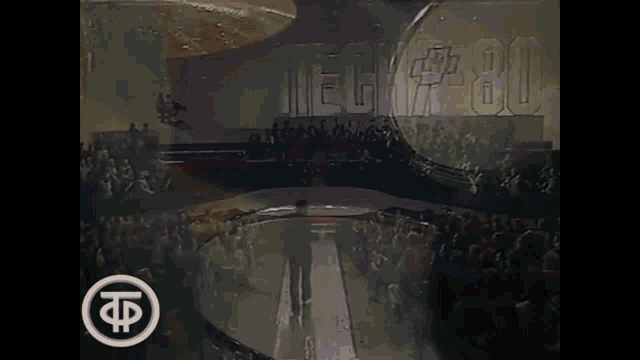 a crowd of people watching a show with the word techa 80 on the wall