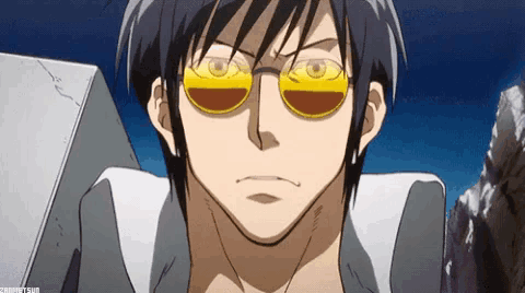 a close up of a man wearing sunglasses and a gray shirt .