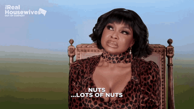 a woman in a leopard print dress is sitting in a chair and says " nuts lots of nuts "