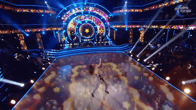a woman is dancing on a stage with a dancing brasil logo