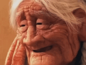 a close up of an elderly woman 's face with her eyes closed .