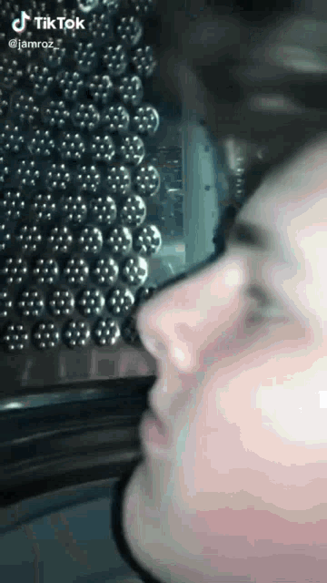 a close up of a person 's face in front of a washing machine with tik tok written on the bottom