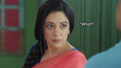 a woman in a red sari is looking at a man and asking him what .