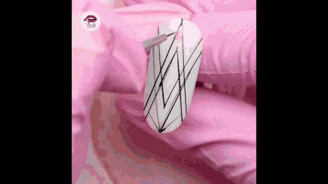 a person is applying nail polish to a nail with a spider web design .