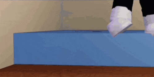 a person is standing on a blue box with their feet up .
