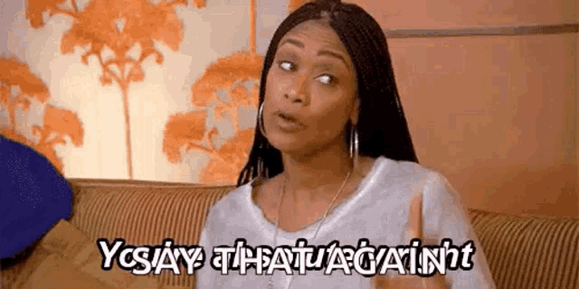 a woman is sitting on a couch and saying yes , that 's against .
