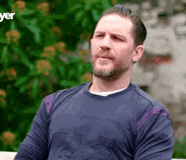 a man with a beard is wearing a blue shirt with the number 76 on it