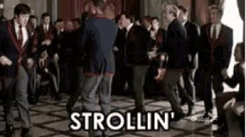a group of men in suits and ties are dancing in a room and the word strolling is on the floor .