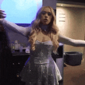 a woman in a white dress has her arms outstretched in a room
