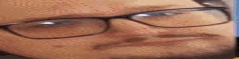 a close up of a man wearing glasses and a beard .