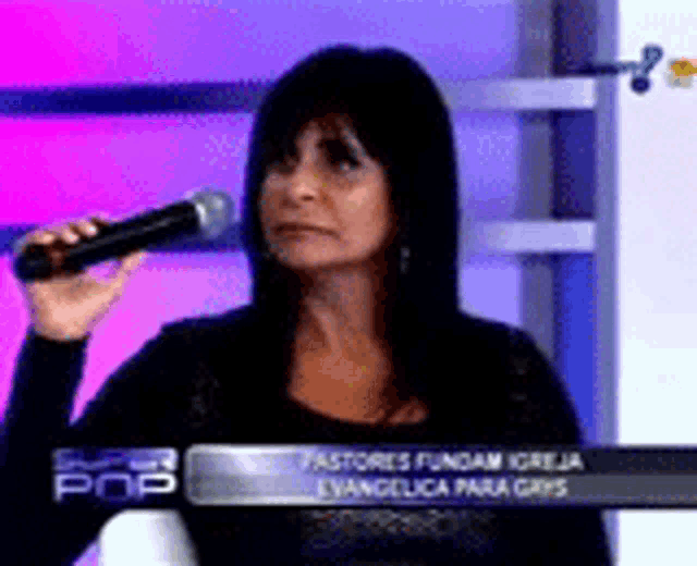 a woman is holding a microphone in front of a sign that says super pop