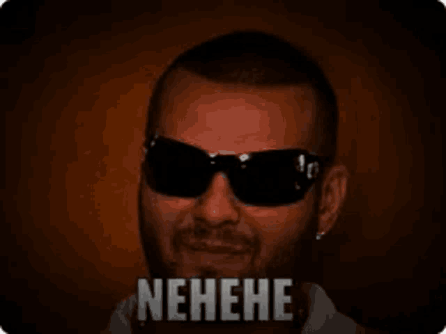 a man wearing sunglasses and a white shirt is making a funny face and saying nehene .