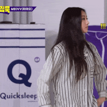 a woman in a striped shirt stands in front of a sign that says quicksleep