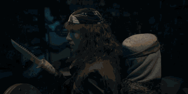 a man in a bandana holds a large knife