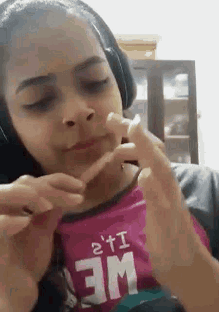 a woman wearing headphones is eating a piece of food with her hands .