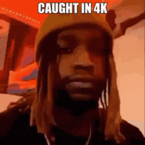 a man wearing a beanie and a necklace with the words `` caught in 4k '' written on it .