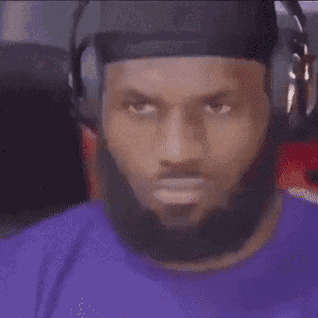 a man with a beard wearing headphones and a black hat