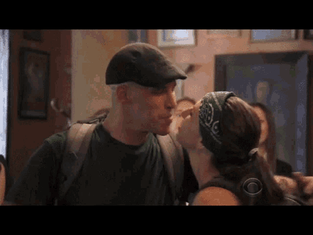 a man and a woman are kissing in a room