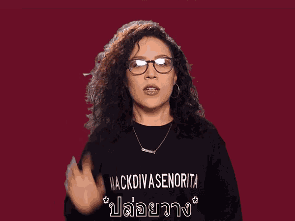 a woman wearing glasses and a black shirt that says mackdivasenorita