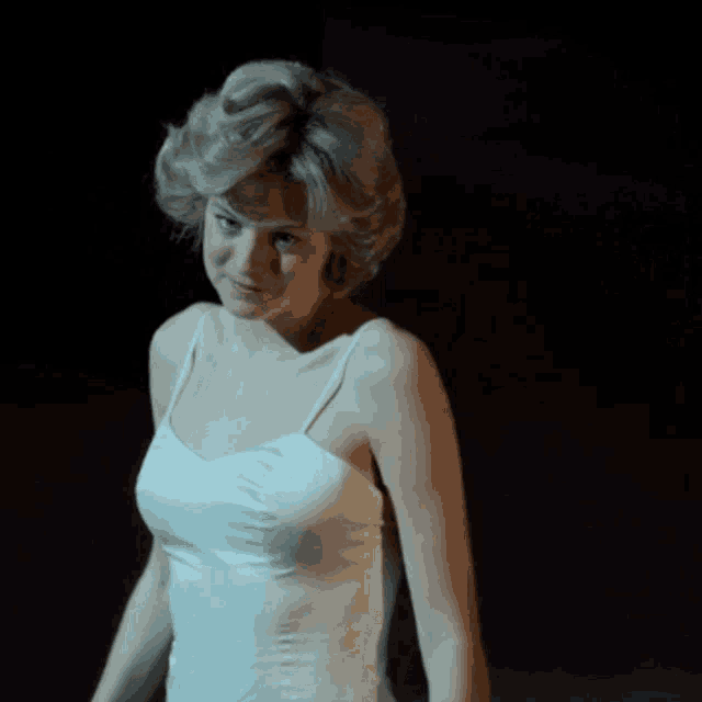 a woman in a white tank top is smiling