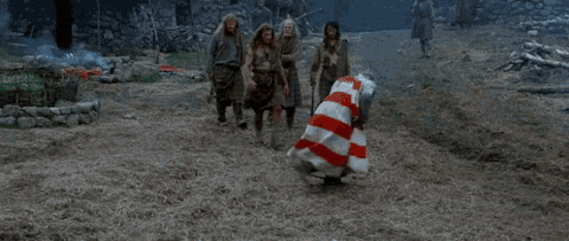 a man in a red and white striped dress is dancing with other people