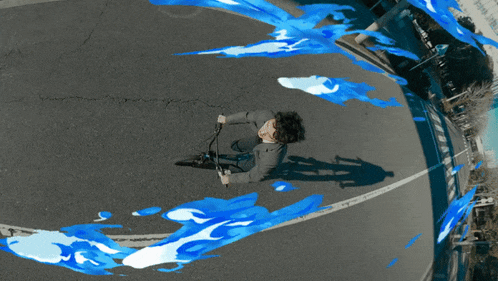 a man is riding a bike down a street with blue flames coming out of it