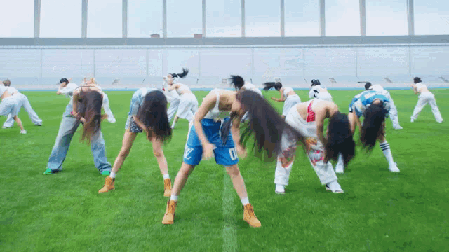 a group of women are doing exercises on a field and one of them has the number 10 on her shorts
