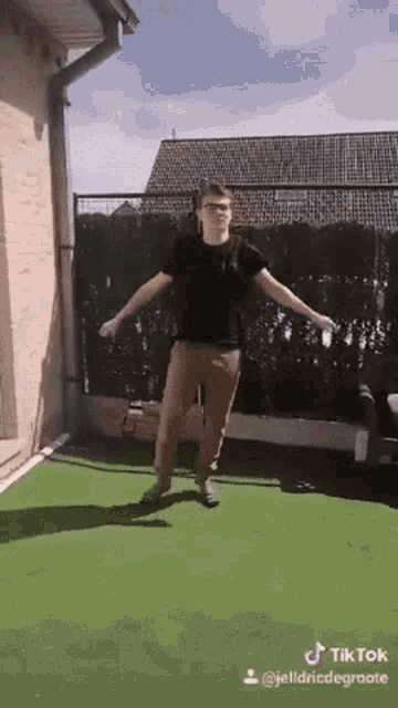 a man in a black shirt is jumping in the air with a tik tok watermark