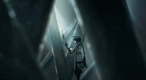 a person is standing in a dark room holding a stick in their hand .
