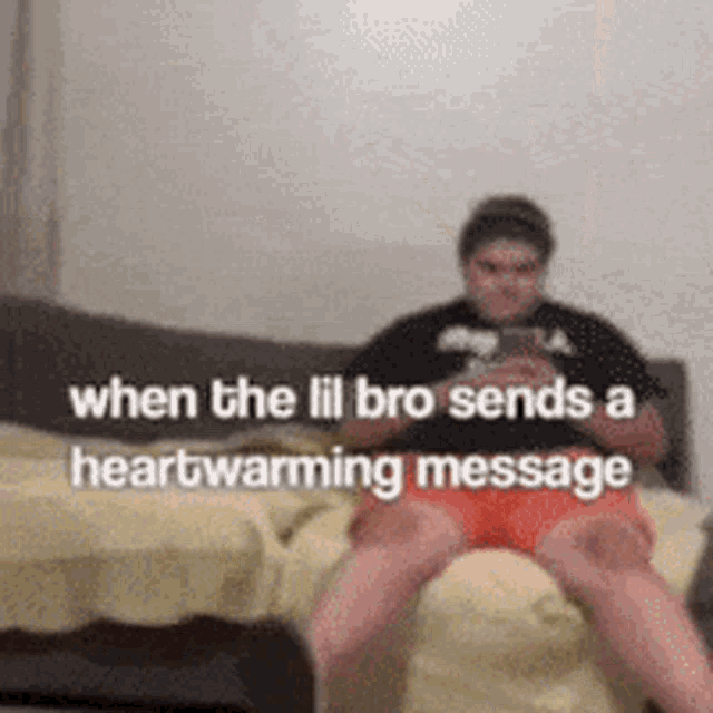 a man is sitting on a couch looking at his phone while the lil bro sends a heartwarming message .