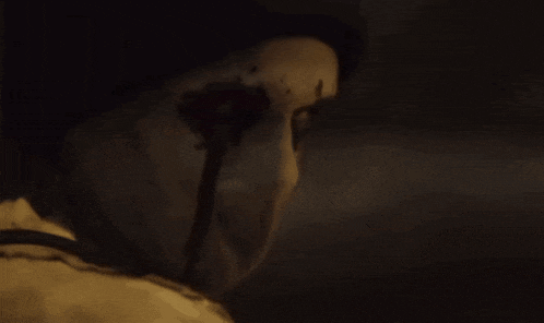a close up of a person 's face with a skull in the dark