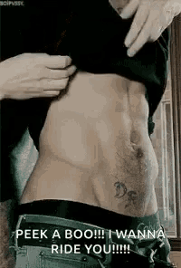 a man with a tattoo on his stomach is taking off his shirt to show his stomach .