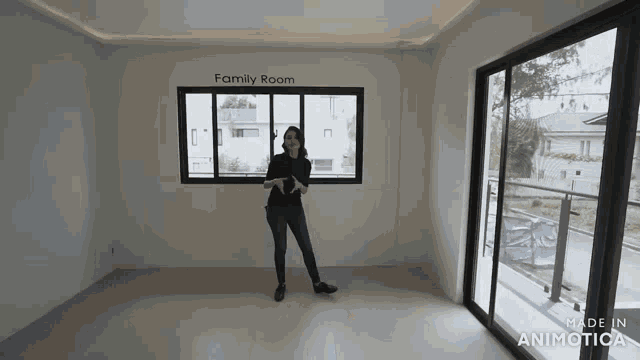 a woman stands in an empty room with the words family room written on the wall