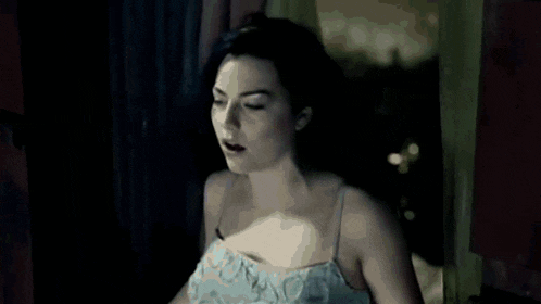 a woman in a white dress is dancing in the dark